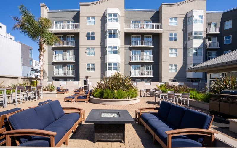 a patio with tables and chairs and umbrellas in front of a building